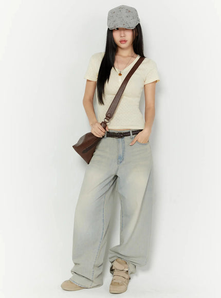Naia Washed Baggy Jeans IU524 Light blue full-body front shot on model styled with cream crop top, floral cap, braided belt, and brown crossbody bag