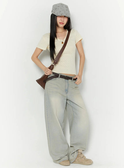 Naia Washed Baggy Jeans IU524 Light blue styled full-body shot on model with cream V-neck crop top, hand in pocket, baggy wide-leg jeans pooling at sneakers