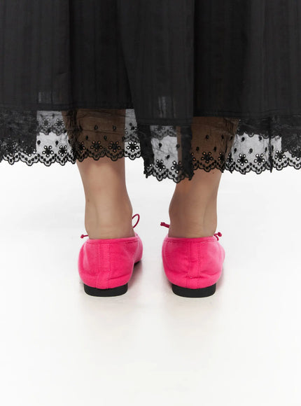 Neon Flats CL510 Pink back close-up on model showing heel counter and flat sole under black lace-hemmed skirt