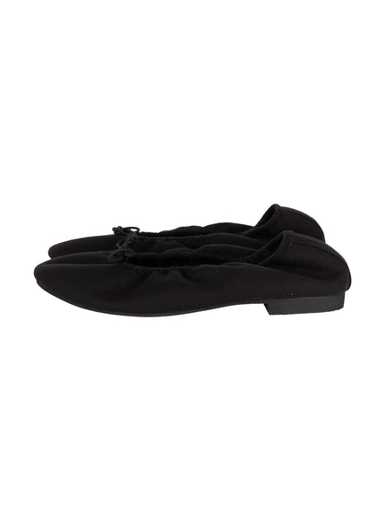 Neon Flats CL510 Black side flat-lay showing pointed silhouette, ruched elastic topline, cord bow, and thin black rubber sole