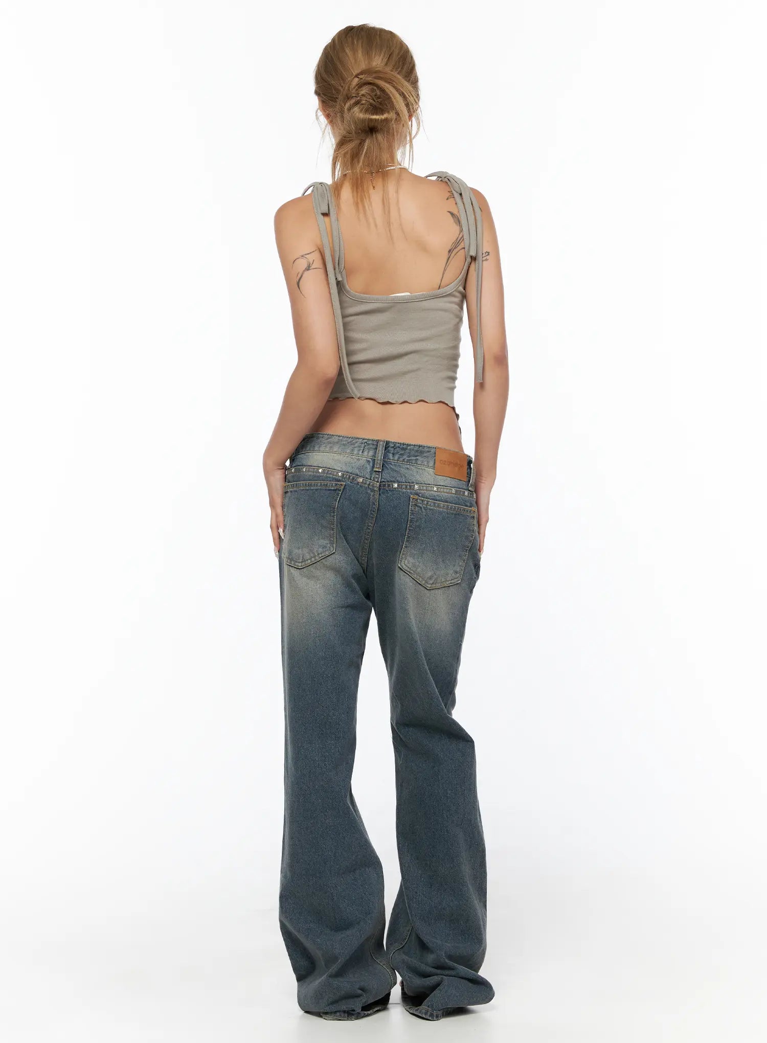 Noel Washed Bootcut Jeans CU524 Blue full back view on model in gray cami showing silver stud-embellished waistband leather logo patch and flared hem