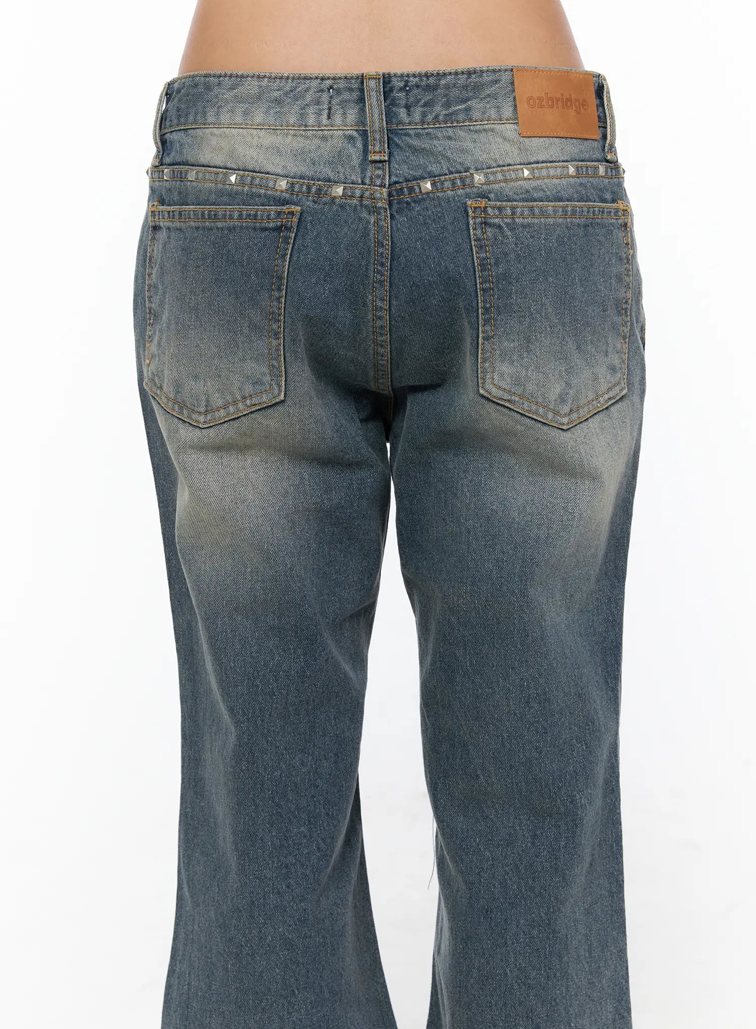 Noel Washed Bootcut Jeans CU524 Blue close-up back detail showing silver pyramid studs along waistband dual back pockets ozbridge leather label and worn wash