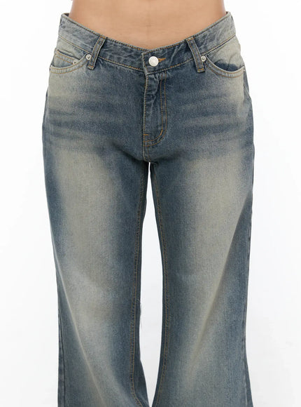 Noel Washed Bootcut Jeans CU524 Blue close-up front detail of V-shaped low-rise waistband button fly side pockets and faded wash denim texture