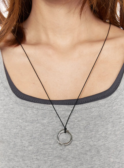 Noir Black Cord Necklace IL522 silver front model close-up worn on neck over gray tank top, black cord with polished spiral ring pendant