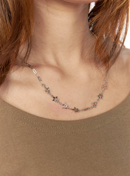 Nova Star Necklace IL517 Silver on-model neck shot showing full necklace drape with open star charms across décolletage over khaki top