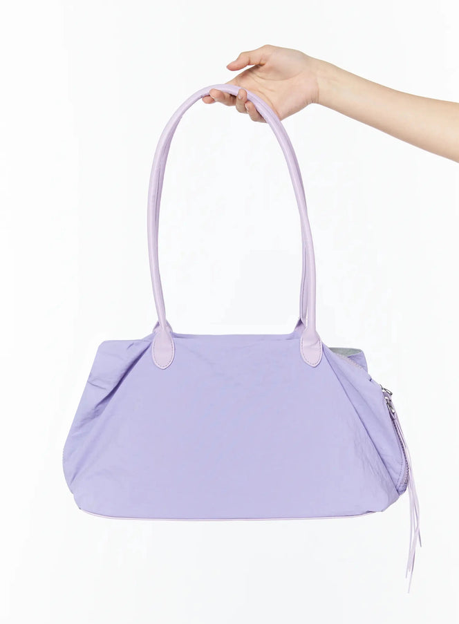LEWKIN Nylon Shoulder Purse IL516 Light purple front shot held by model hand showing nylon body dual top handles and side zipper pull