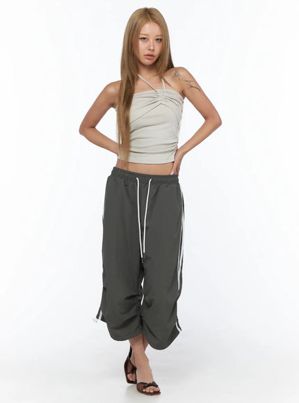 Nylon Track Bermuda Pants CU523 Dark gray front full-body shot on model with hands on hips wearing crop halter top and heeled sandals