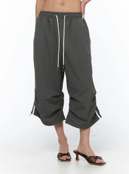 Nylon Track Bermuda Pants CU523 Dark gray front close-up on model showing elastic drawstring waist white stripe detail and gathered hem