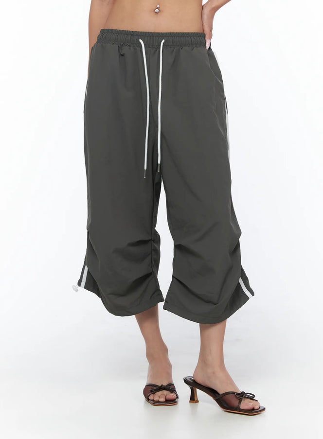 Nylon Track Bermuda Pants CU523 Dark gray front close-up on model showing elastic drawstring waist white stripe detail and gathered hem