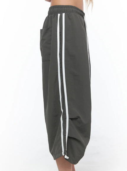 Nylon Track Bermuda Pants CU523 Dark gray side close-up on model showing white double side stripe elastic waistband side pocket and hem toggle