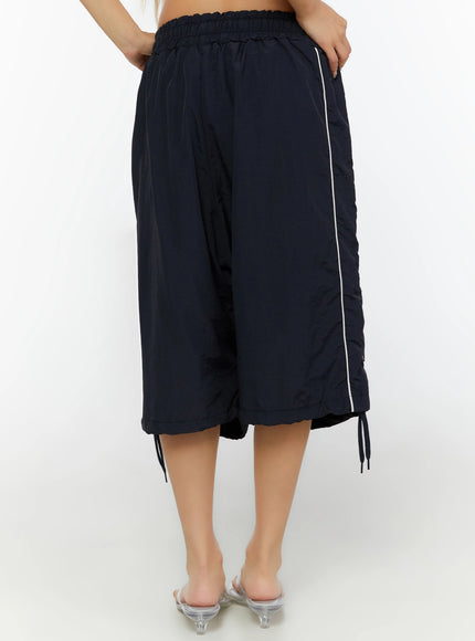 Nylon Wide-Leg Shorts IL524 Dark blue back shot on model showing elasticated waist, white side piping, wide cropped hem, and ankle tie drawstrings