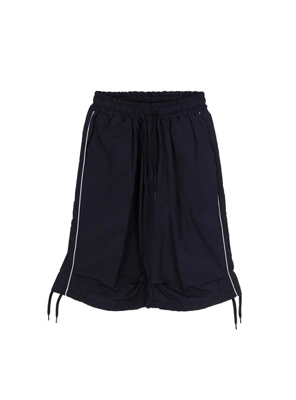 Nylon Wide-Leg Shorts IL524 Dark blue flat-lay front view showing elasticated drawstring waist, white side piping, layered wide hem, and ankle tie cords