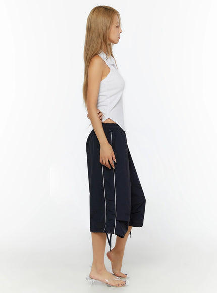 Nylon Wide-Leg Shorts IL524 Dark blue full-body side shot on model in white halter top showing side white piping stripe and layered balloon hem