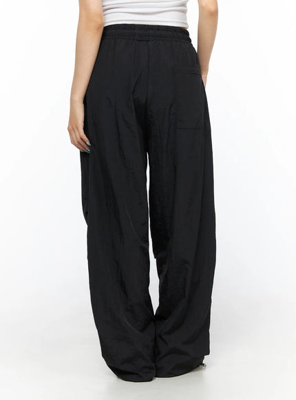 Nylon Wide Pants CL514 Black back view on model showing elastic waistband, back patch pocket and voluminous wide-leg crinkled nylon fabric