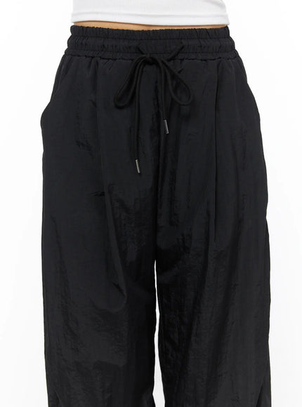 Nylon Wide Pants CL514 Black close-up waist detail on model showing elastic ruched waistband drawstring with metal tip and side pocket
