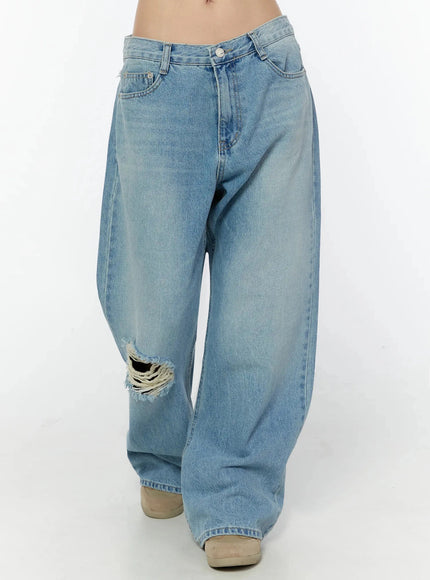 Odette Distressed Semi-Wide Jeans IU524 Blue front angled close-up on model showing low-rise fit, V-cut waistband, front pockets and frayed knee hole detail