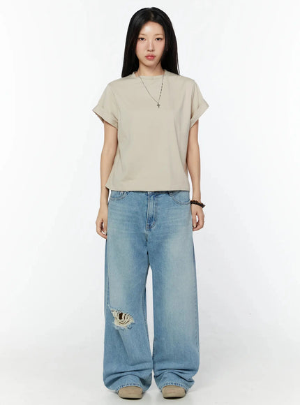 Odette Distressed Semi-Wide Jeans IU524 Blue full-body front shot on model in beige tee, standing upright, arms at sides, highlighting knee rip and wide-leg length