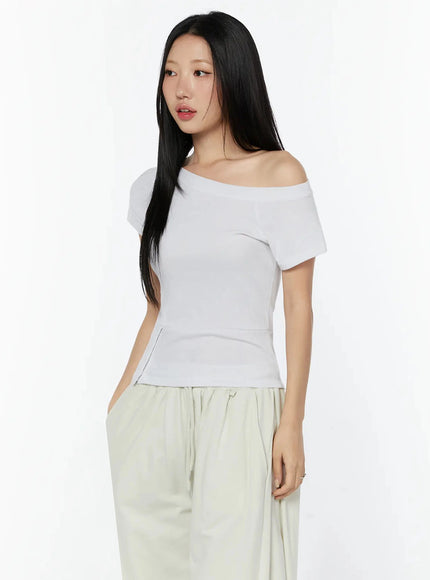 Off-Shoulder Buttoned Slit Tee IU524 White side shot model three-quarter showing off-shoulder neckline and front slit waist seam detail