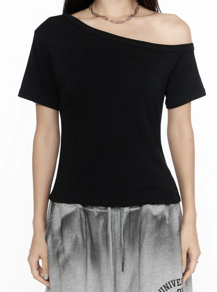 Off-Shoulder Casual Tee CL527 Black close-up front torso shot on model, asymmetric off-shoulder neckline and short sleeve detail, smooth jersey fabric, chain necklace