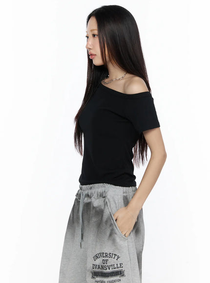 Off-Shoulder Casual Tee CL527 Black side profile close-up on model, asymmetric off-shoulder neckline detail, short sleeve, slim crop silhouette, chain necklace accessory