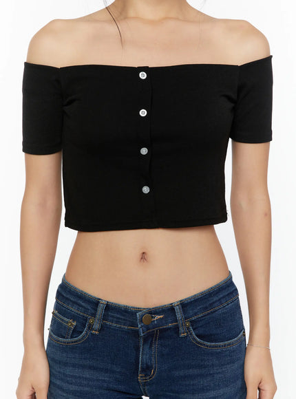 Off-Shoulder Crop Top CU529 Black close-up front detail shot showing silver button placket, off-shoulder ribbed knit construction and cropped midriff-baring hem