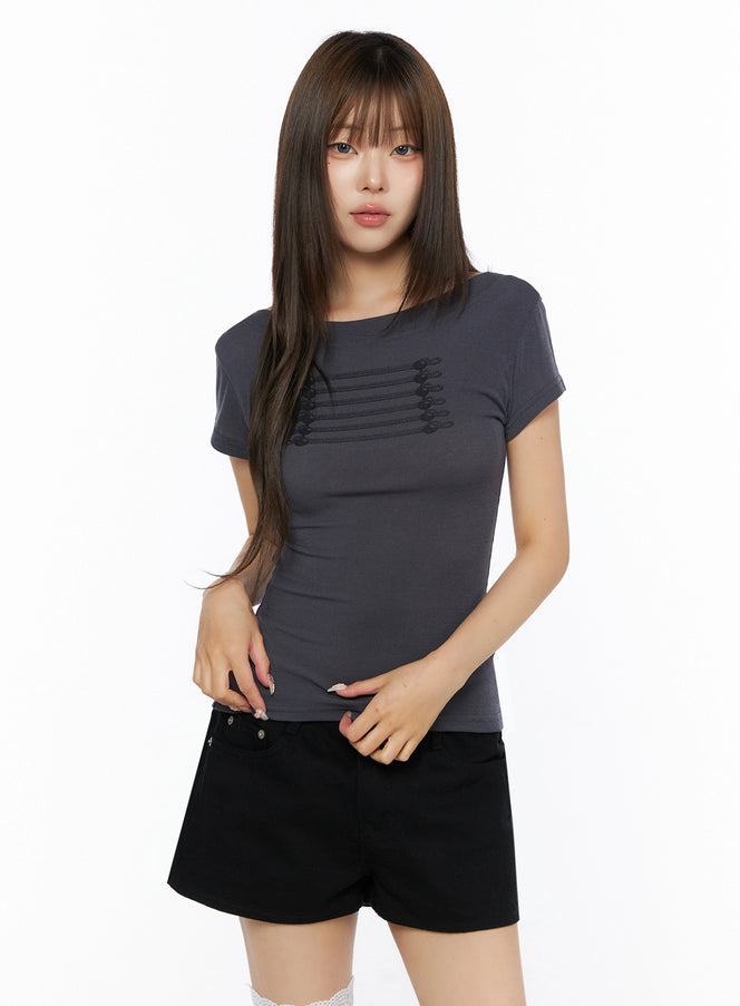Off-Shoulder Crop Top IL523 charcoal gray front shot on model wearing black shorts, crew-neck short-sleeve tee with tonal horizontal cord and button embellishment