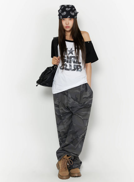 Off-Shoulder Graphic Print Top IL523 White full-length front shot on model styled with paisley bandana hat black bag tan boots and camo wide-leg pants