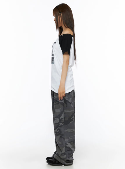 Off-Shoulder Graphic Print Top IL523 White side shot on model showing silhouette length asymmetric off-shoulder neckline black raglan sleeve star stud detail