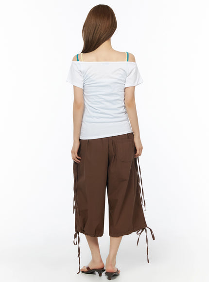 Off-Shoulder Graphic Short Sleeve Top IU525 White back shot on model showing wide off-shoulder neckline, short sleeves, fitted body, colorful bra straps detail