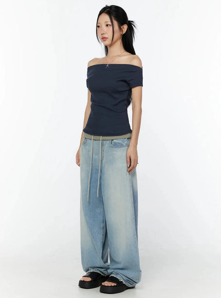 Off-Shoulder Ribbed Short Sleeve Top IU524 Dark blue side full-body model shot gazing away styled with wide-leg light-wash drawstring jeans and black platform sandals