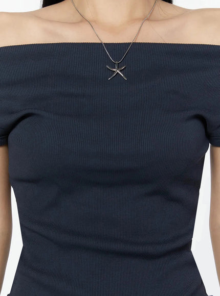 Off-Shoulder Ribbed Short Sleeve Top IU524 Dark blue close-up detail shot showing ribbed texture off-shoulder neckline and silver star pendant necklace on model