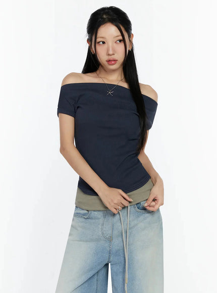 Off-Shoulder Ribbed Short Sleeve Top IU524 Dark blue upper-body front model shot hands clasped at waist showing off-shoulder ribbed crop fit with silver star necklace
