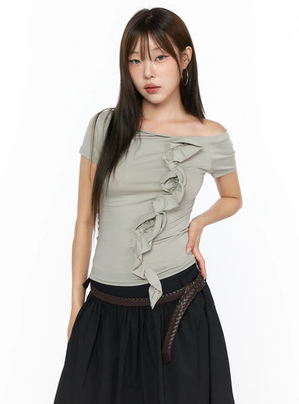 Off-Shoulder Ruffle Tee CL517 light grey front shot on model hand on hip, off-shoulder neckline with vertical ruffle trim, styled with black skirt and braided belt
