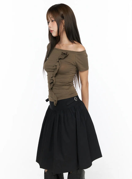 Off-Shoulder Ruffle Tee CL517 Dark beige side profile shot on model, vertical ruffle detail emphasized, slim knit fabric, paired with black gathered skirt and boots