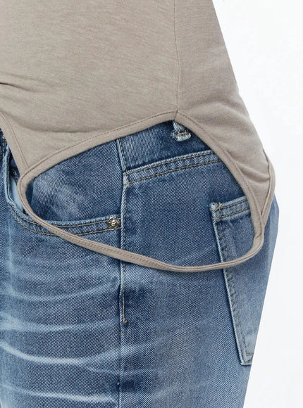 Off-Shoulder Two-Way Cami Top IU525 Beige close-up detail shot of curved asymmetric hem cutout and front pocket of jeans showing layering effect