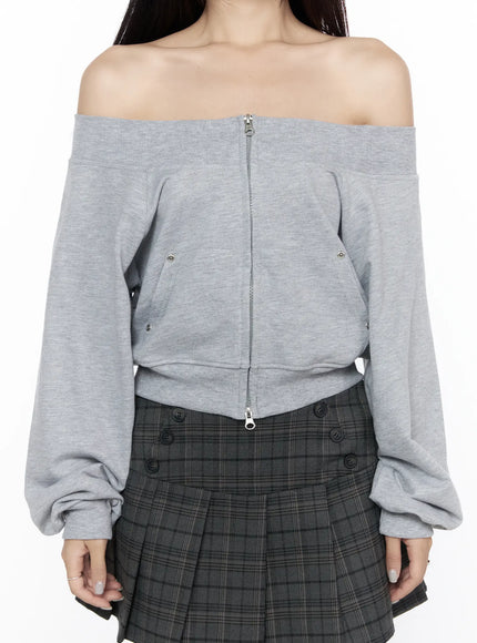 Off-Shoulder Zip-Up Cardigan CL527 Gray close-up torso shot on model showing center zip, snap buttons, kangaroo pocket detail and ribbed hem, off-shoulder neckline emphasized