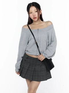 LEWKIN Off-Shoulder Zip-Up Cardigan CL527 Gray S/M front shot on model wearing crossbody bag and dark plaid mini skirt, off-shoulder neckline with center zip and snap details