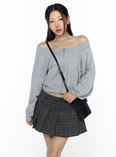 LEWKIN Off-Shoulder Zip-Up Cardigan CL527 Gray S/M front shot on model wearing crossbody bag and dark plaid mini skirt, off-shoulder neckline with center zip and snap details