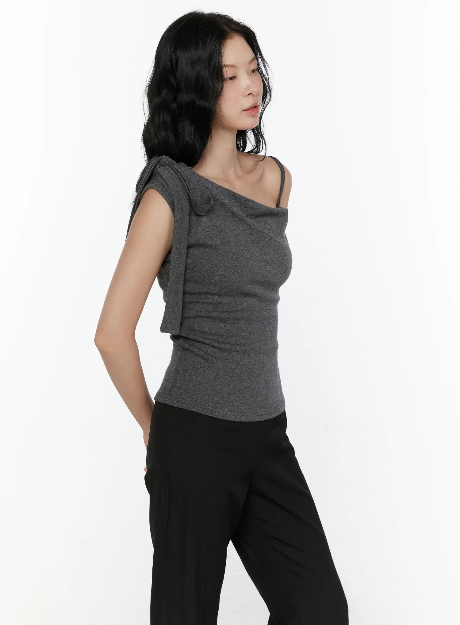 One-Shoulder Bow Top CL521 Dark gray side model half-body shot hand in pocket revealing side silhouette of fitted knit and asymmetric strap bow