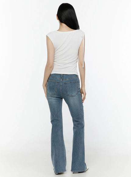 One Shoulder Ribbon Shirred Sleeveless Top IL506 White back shot on model showing plain smooth back, shoulder ribbon tie, with flare jeans and white heels