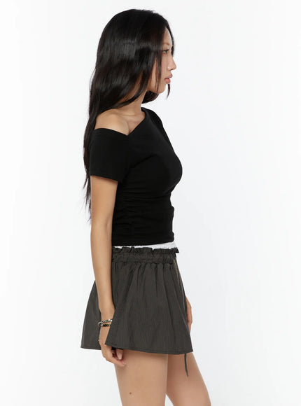 One-Shoulder Shirred Short Sleeve Top CU529 Black side profile close-up on model highlighting asymmetric off-shoulder neckline and ruched body detail