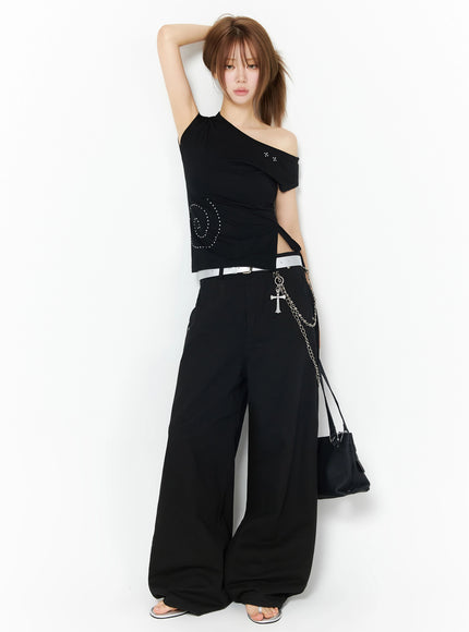 One-Shoulder Spiral Top IL502 Black full-length front shot on model with arm raised overhead, styled with white belt, chain accessory, wide-leg pants, and black bag