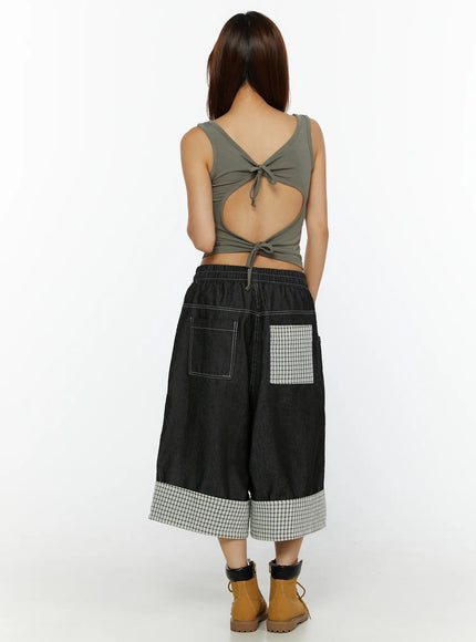 Open-Back Tank Top CL515 dark green back shot on model showing open-back V-cutout with double tie closure, styled with black denim wide-leg culottes and tan boots