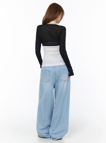 Ophelia Distressed Baggy Jeans IL502 Light blue back full-body shot on model in black cardigan revealing large patch back pockets and voluminous wide-leg silhouette