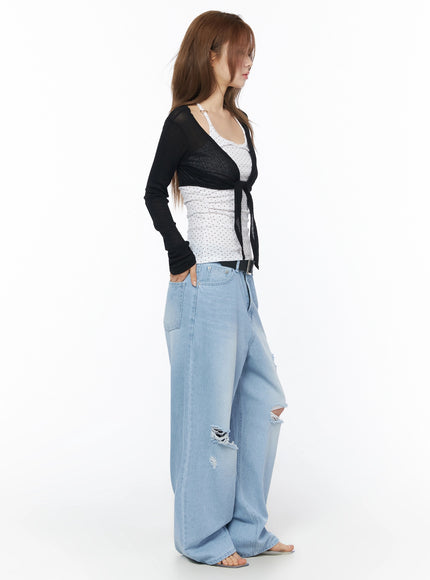 Ophelia Distressed Baggy Jeans IL502 Light blue side full-body shot on model in black tie-front cardigan showing ripped knee distressing and baggy wide-leg denim profile