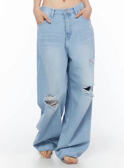 Ophelia Distressed Baggy Jeans IL502 Light blue front crop shot on model hands in pockets showing waistband button fly and heavy knee distressing with frayed holes