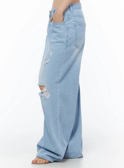 Ophelia Distressed Baggy Jeans IL502 Light blue side crop shot on model hand in pocket highlighting side rip distressing large patch pocket and wide-leg hem pooling