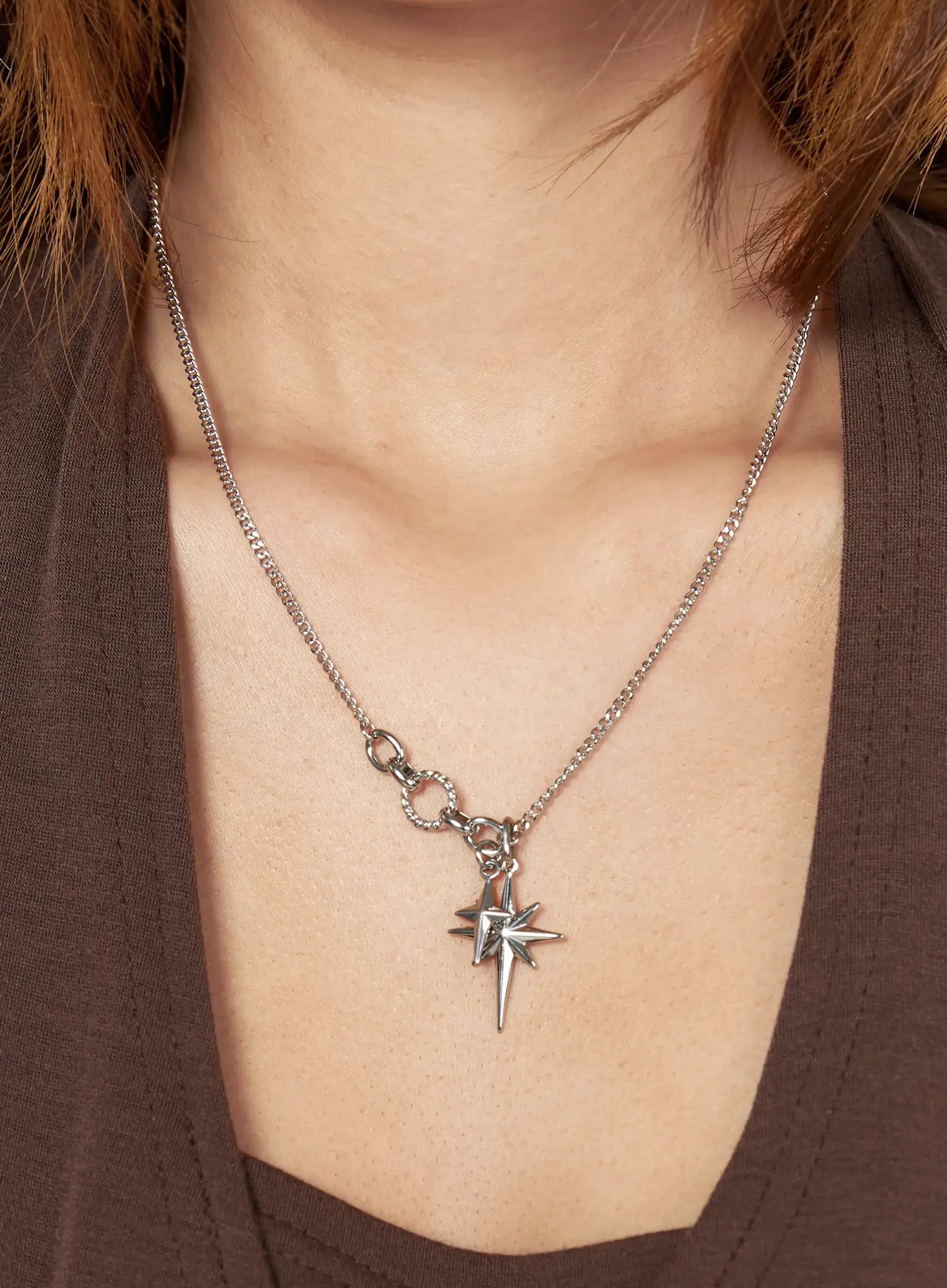 Orion Double Cross Necklace IL517 Silver front close-up on model neck showing double north star pendants on curb chain styled with brown top
