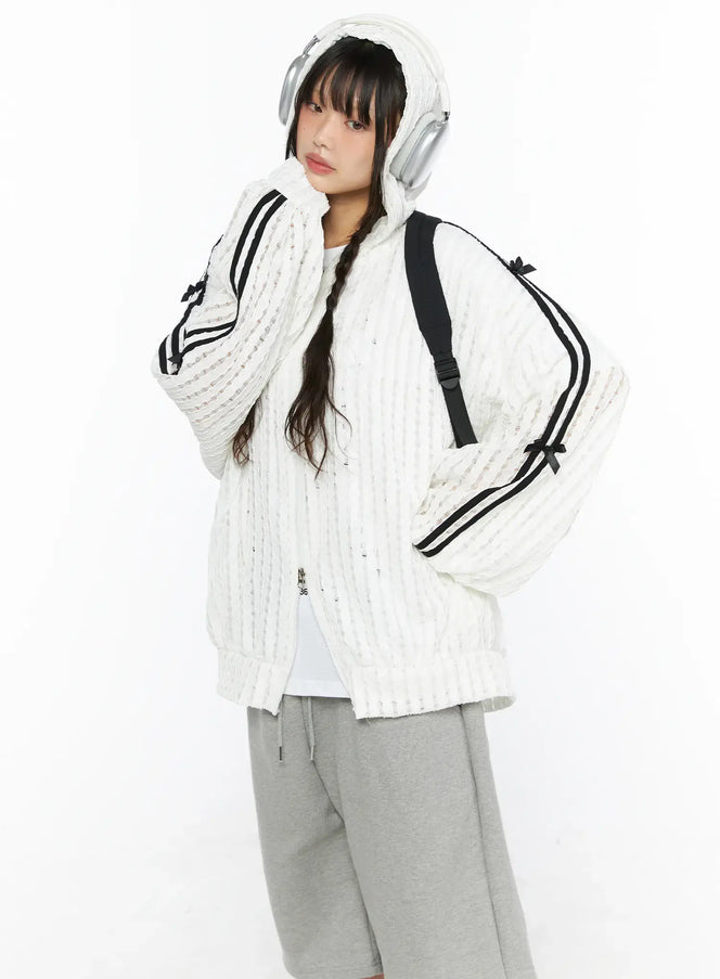LEWKIN Oversized Bow Detail Windbreaker CU530 White M/L three-quarter front view on model wearing hood with headphones black backpack gray shorts sneakers