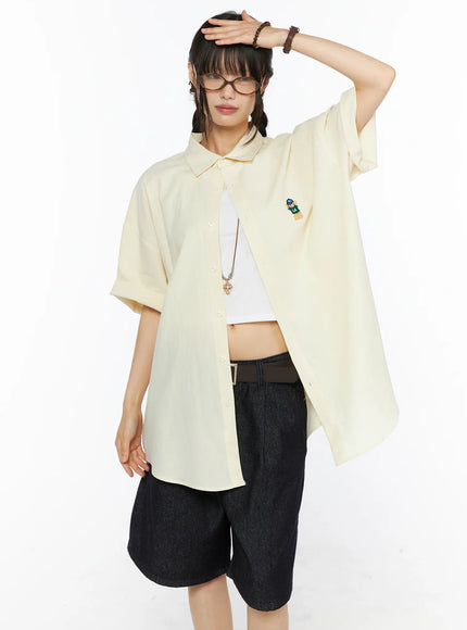 LEWKIN Oversized Button-Up Shirt CU530 Light yellow front shot on model size M/L hand raised to forehead open over white crop top with denim shorts